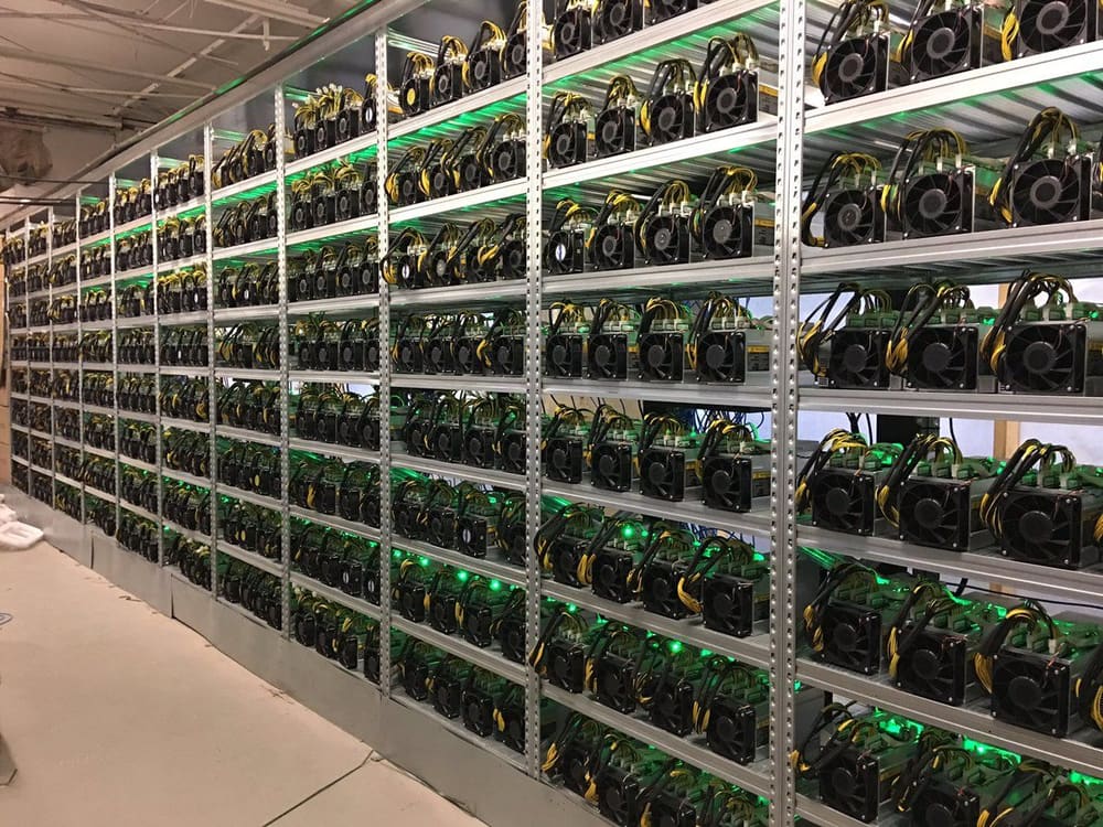 A mining facility. Racks of specialised hardware that does nothing but hash, and this is the physical form the security guarantee takes